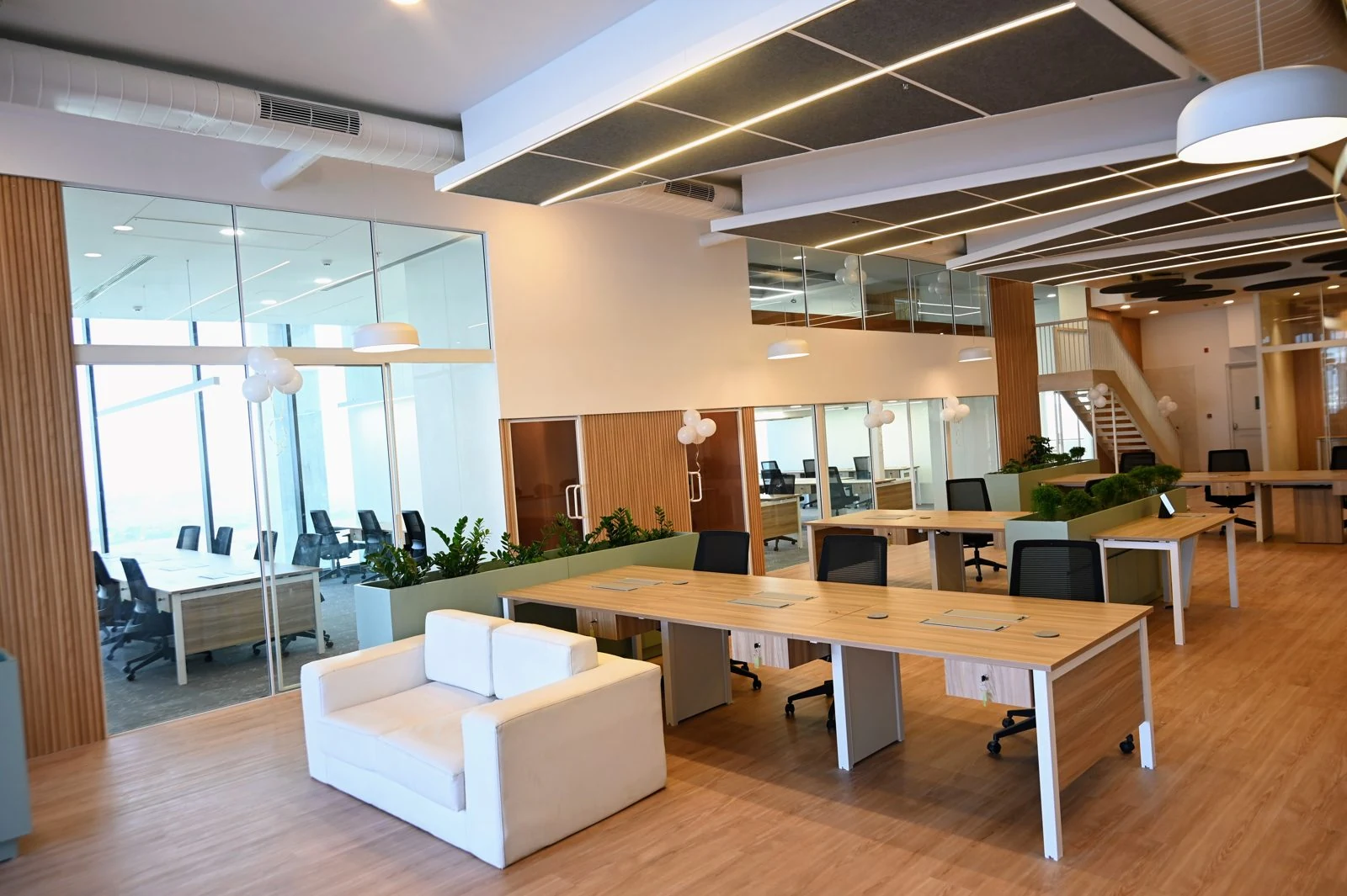 Finished open-plan workspace at OP Tower with glass meeting rooms, timber finishes and integrated planting
